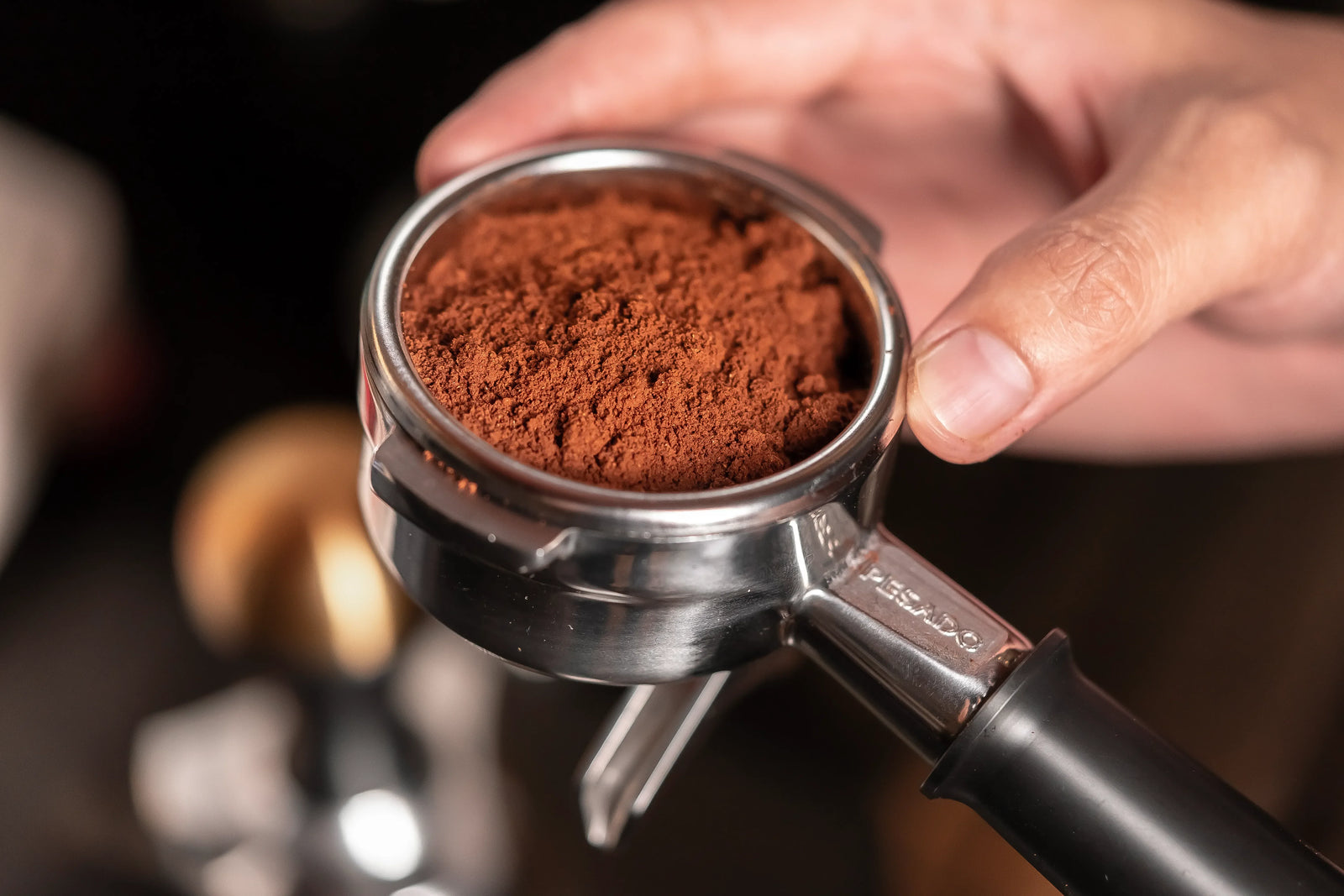 A portafilter filled with a few grams of coffee needed for espresso